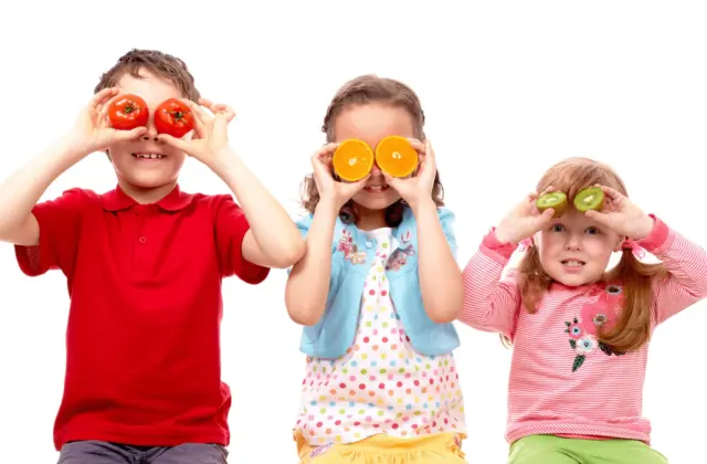 smiling kids with fruit in their eyes